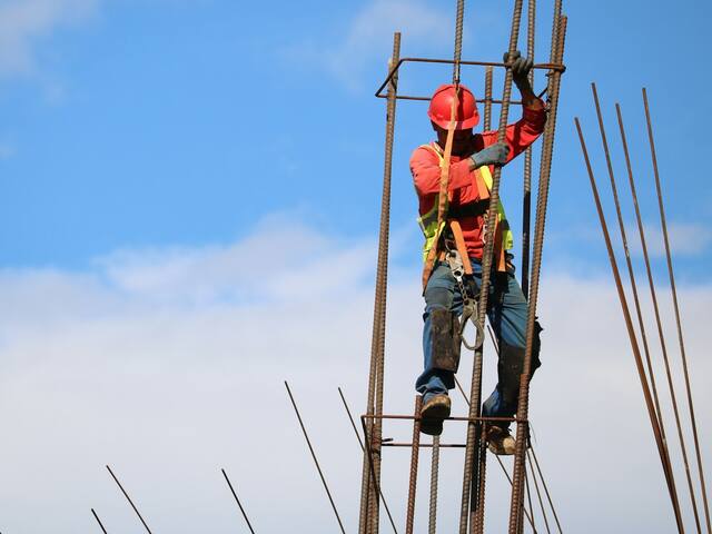 A worker climbing a rebar column cage.