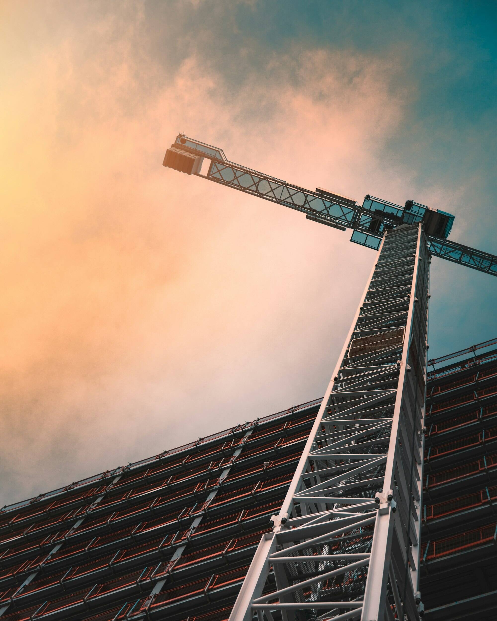 A tower crane from below at sunrise.